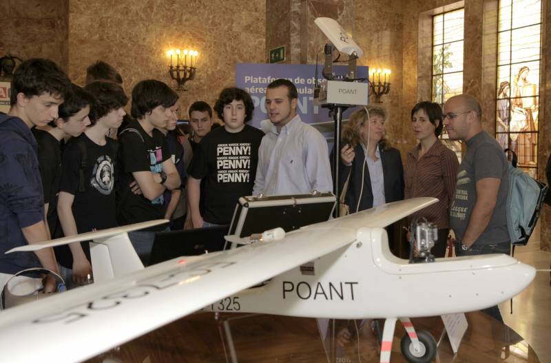 Enrique plaza (con camisa en el centro), explica a un grupo de estudiantes las características de su prototipo
