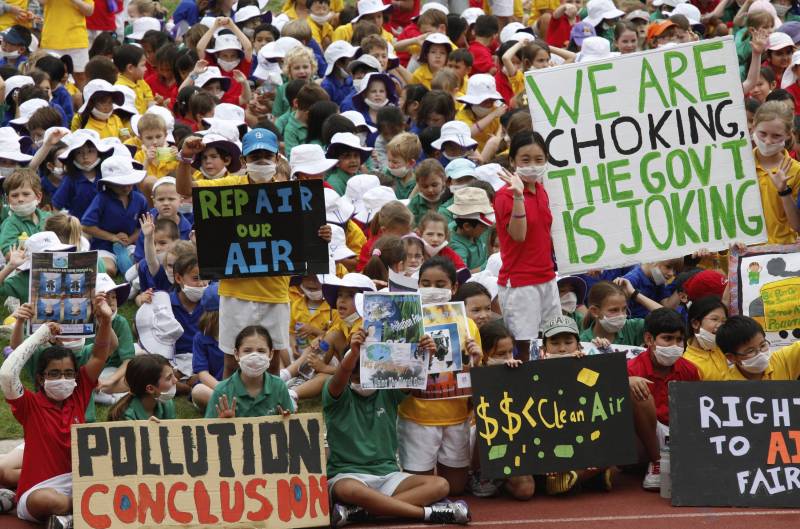 Niños de la escuela Kennedy protestan contra los altos niveles de contaminación ambiental en Hong Kong (China) en la víspera de celebración del Día del Planeta.  