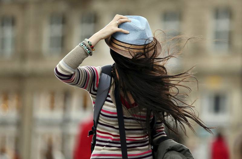 Una mujer se sostiene el sombrero mientras lucha contra el viento en Colonia (Alemania). / EFE 