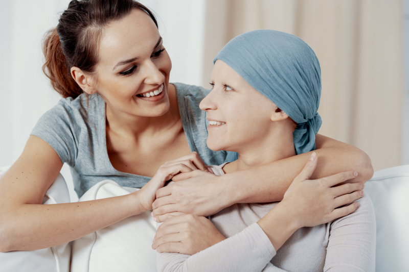una mujer con cáncer se abraza con otra