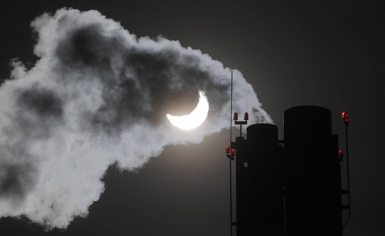 El humo sale de la chimenea de una caldera de gas durante un eclipse solar parcial en Moscú (Rusia). Desde esta ciudad el sol se ocultó en un 70 %. / © Maxim Shipenkov (EFE)