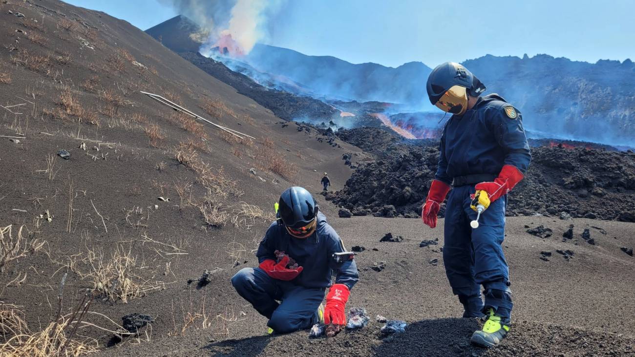 Investigadores del Instituto Geológico y Minero de España tomando muestras de escoria, lava y temperatura (superior a 800 °C en ese momento) sobre la parte superior de la colada norte.