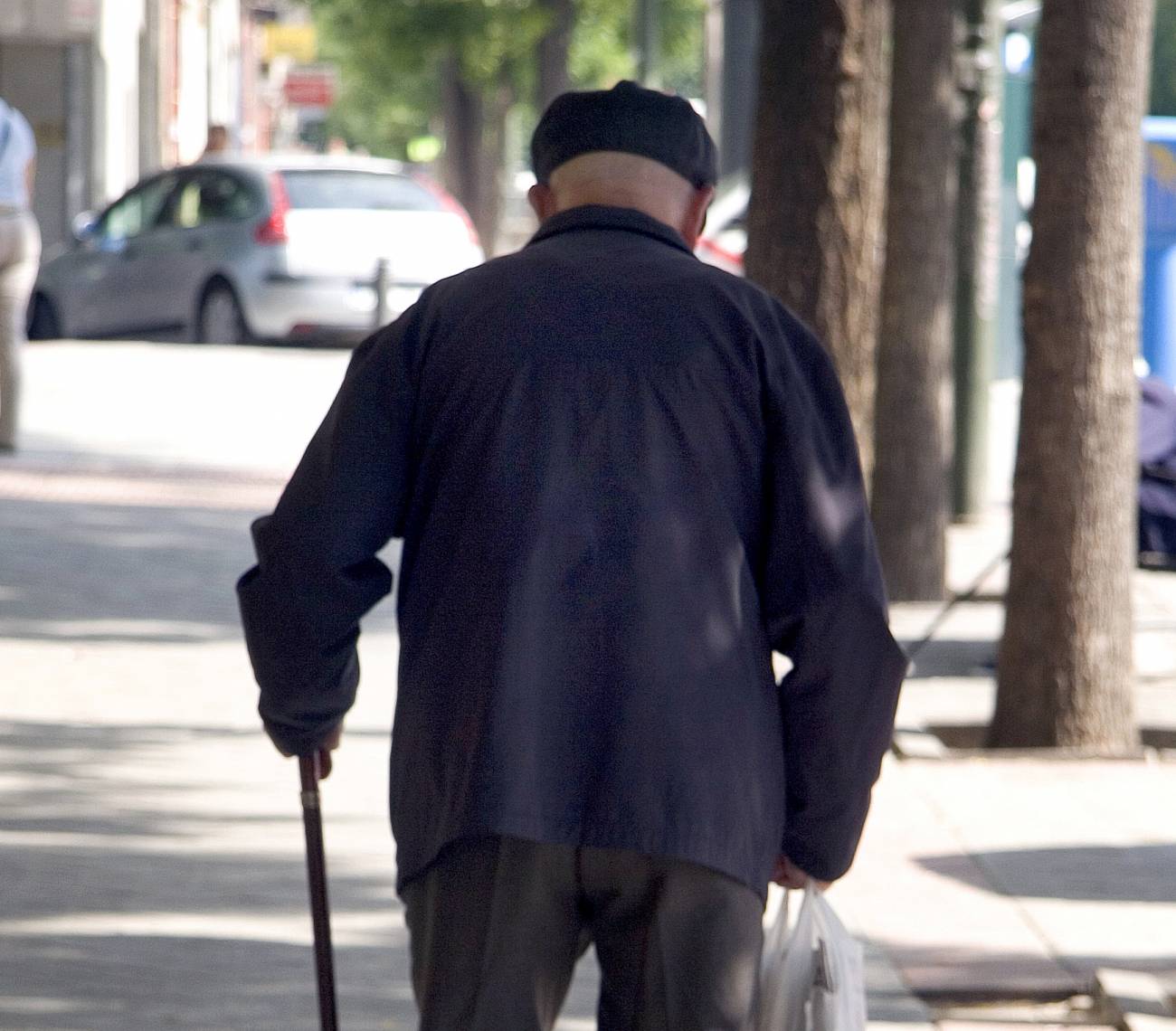 Anciano paseando por la calle.