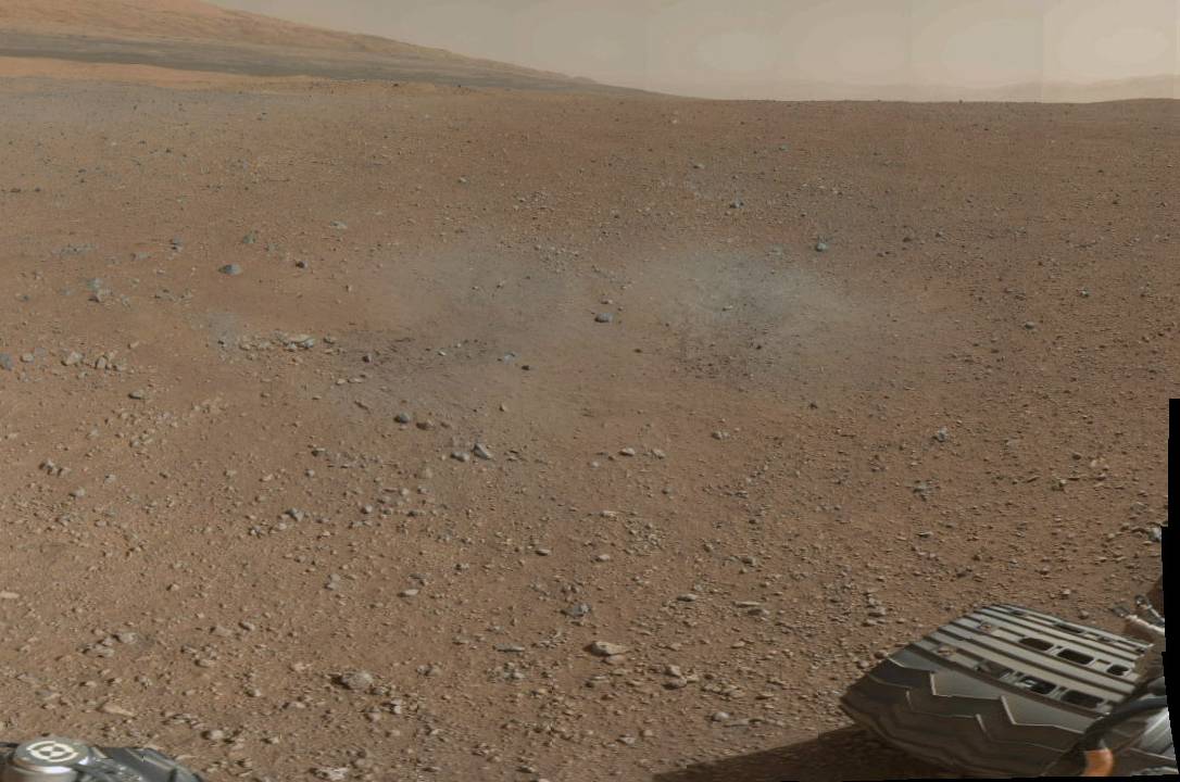 Fragmento de la panorámica a color tomada por Curiosity. La zona grisácea delata los efectos de los retrocohetes durante el aterrizaje.  