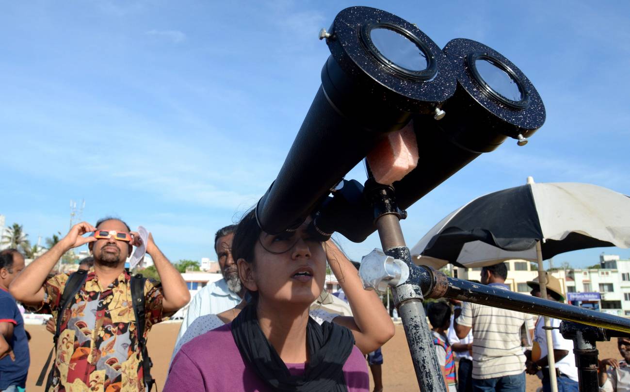 Una mujer observa a través de un telescopio el tránsito del planeta Venus entre la Tierra y el Sol hoy, miércoles 6 de junio de 2012, en Chennai (India). El segundo planeta del sistema solar fue visto desde la India como un pequeño punto negro interpuesto frente al sol. Este mismo fenómeno sólo se repetirá hasta 2117.