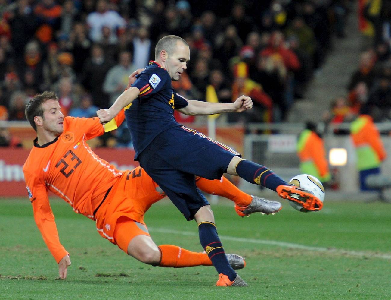 Iniesta golpea el balón ante Van der Vaart. / EFE 