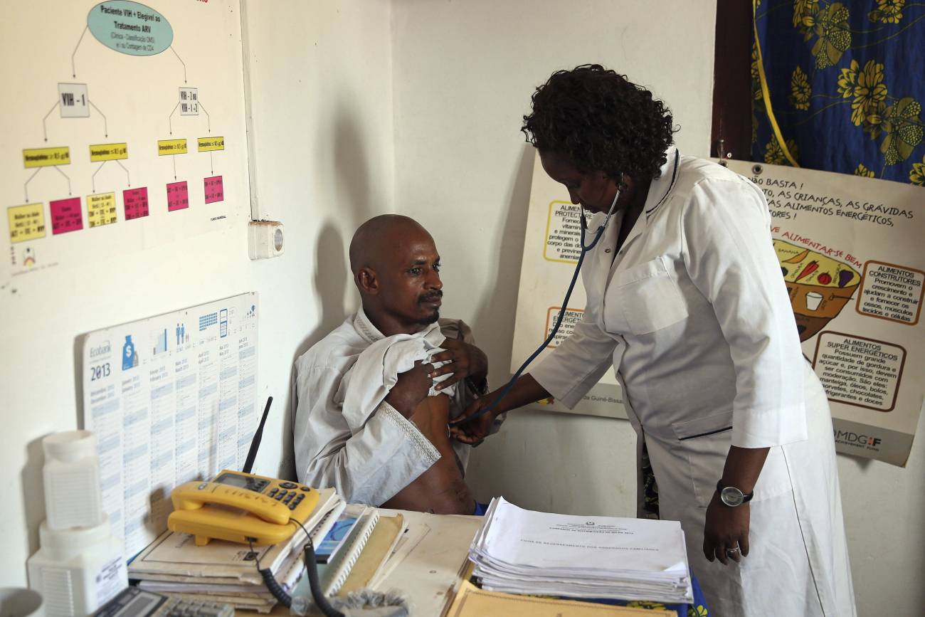 La enfermera guineana Egidia Almeida (der) osculta a un ciudadano procedente de Guinea Conakry en un centro médico a la entrada fronteriza de Buruntuma (Guinea-Bissau). / EFE/Tiago Petinga
