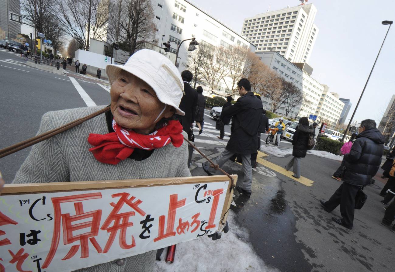 Una anciana japonesa sujeta un cartel con el mensaje "No a la energía nuclear".