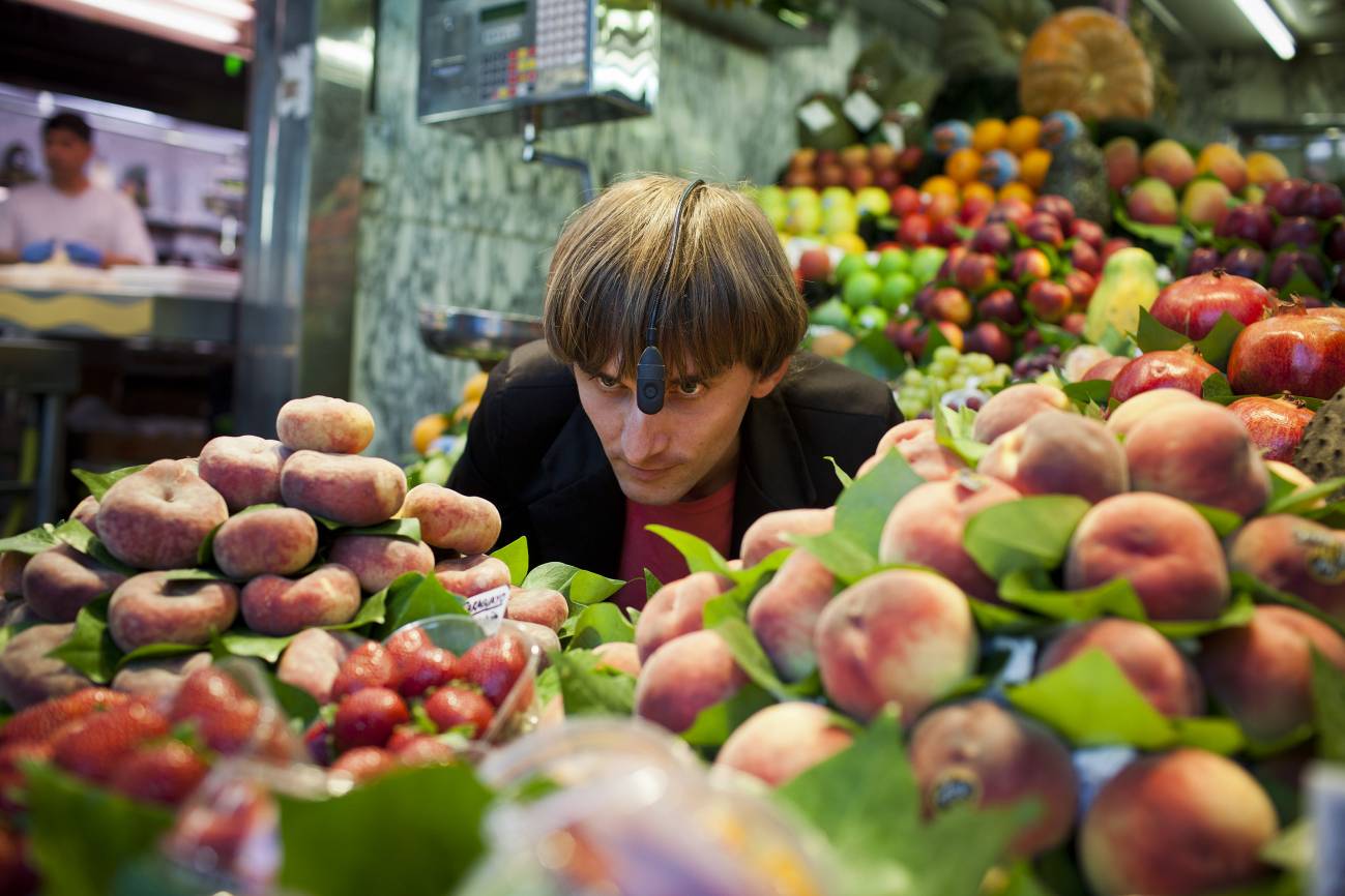 Neil Harbisson mira los colores de las frutas a través de su eyeborg en un mercado barcelonés.
