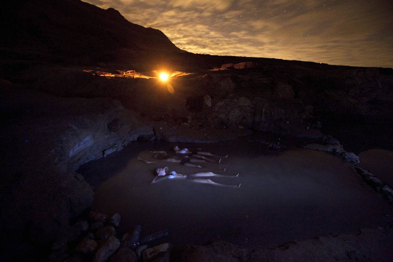 Fotografía de larga exposición con un grupo de israelíes esperando la lluvia de meteoros de las Gemínidas este viernes mientras tomaban un baño cerca a las costas del mar Muerto, en Israel.