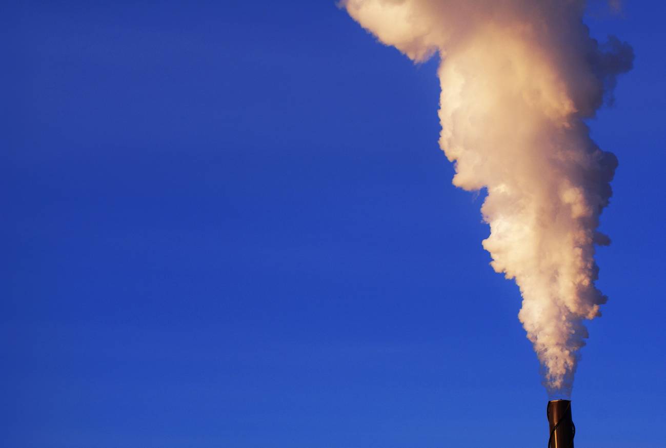 Una chimenea expulsa gases contaminantes a la atmósfera