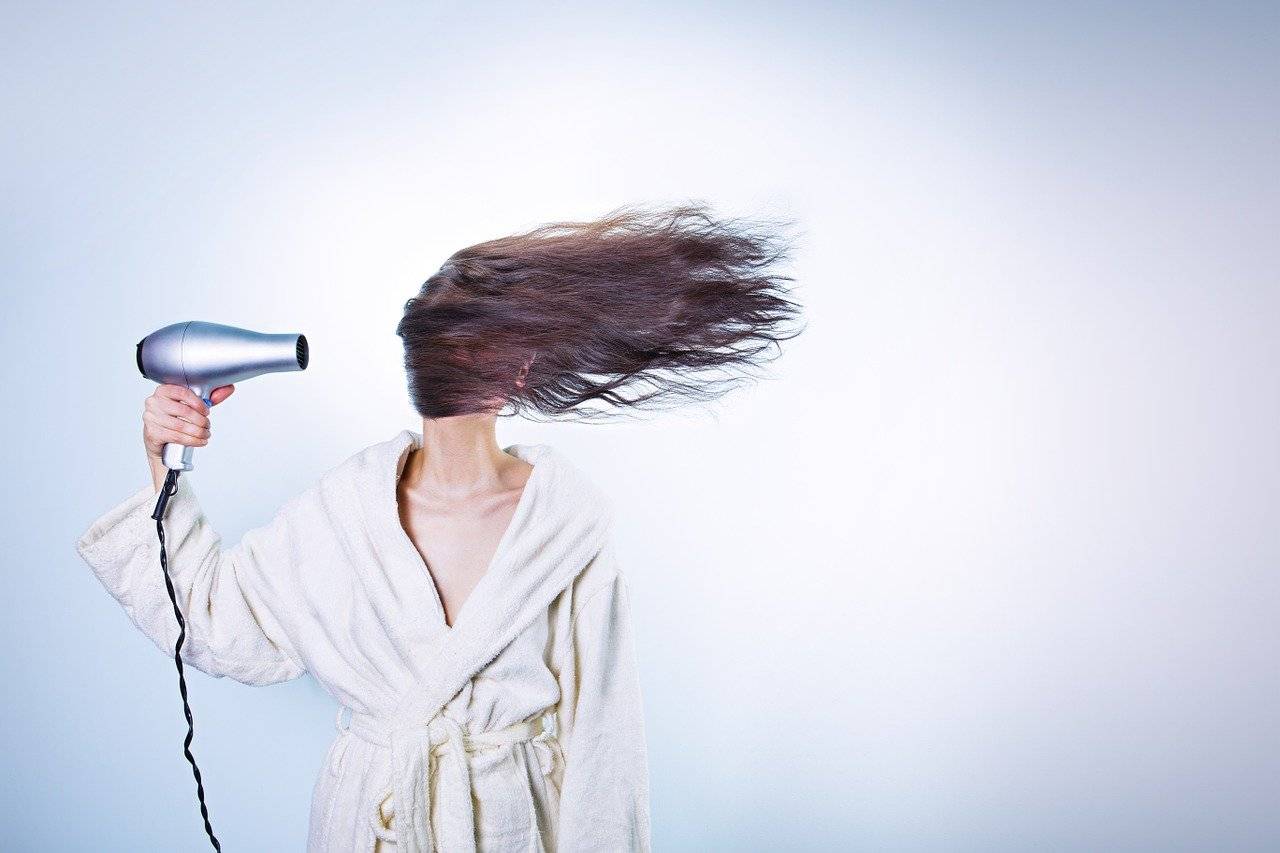 mujer secándose el pelo con mucha intensidad