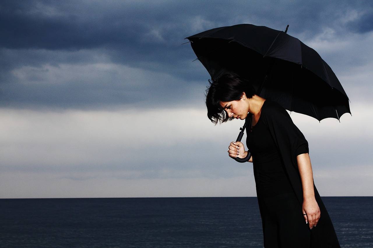 mujer de negro con un paraguas