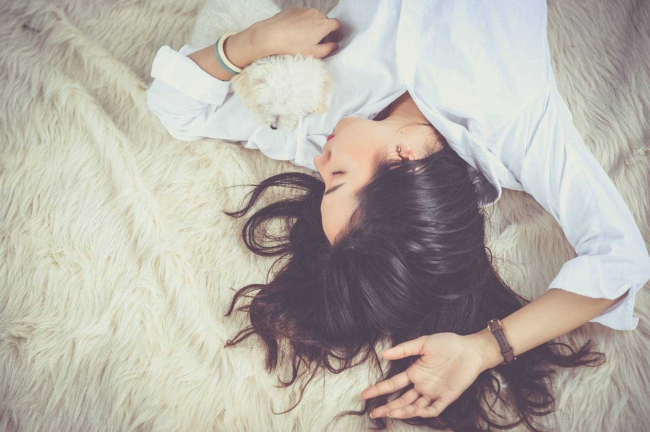 mujer durmiendo en una cama con un perro
