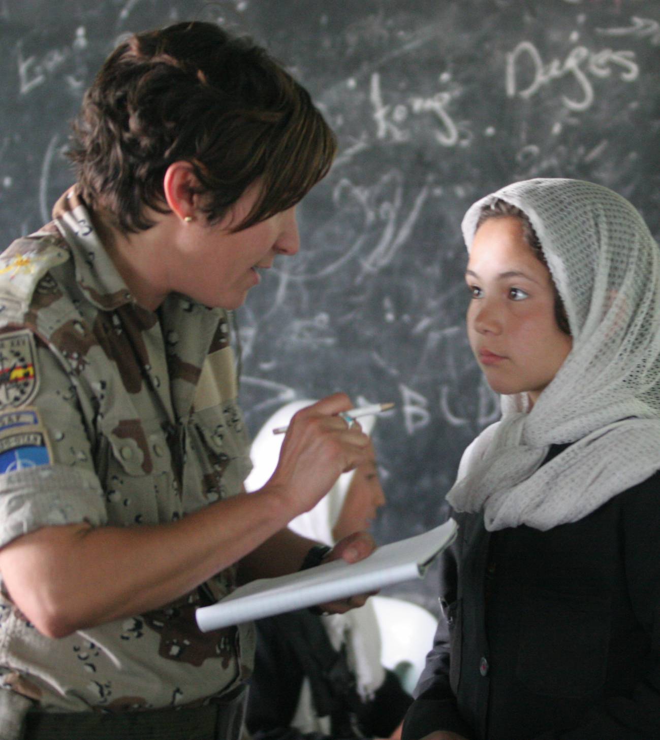 Personal militar trabajando con la población local en una zona de conflicto. 