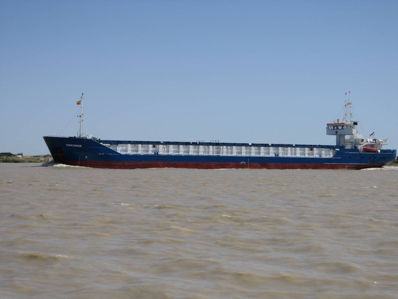 Barco navegando hacia la desembocadura del estuario del Guadalquivir.