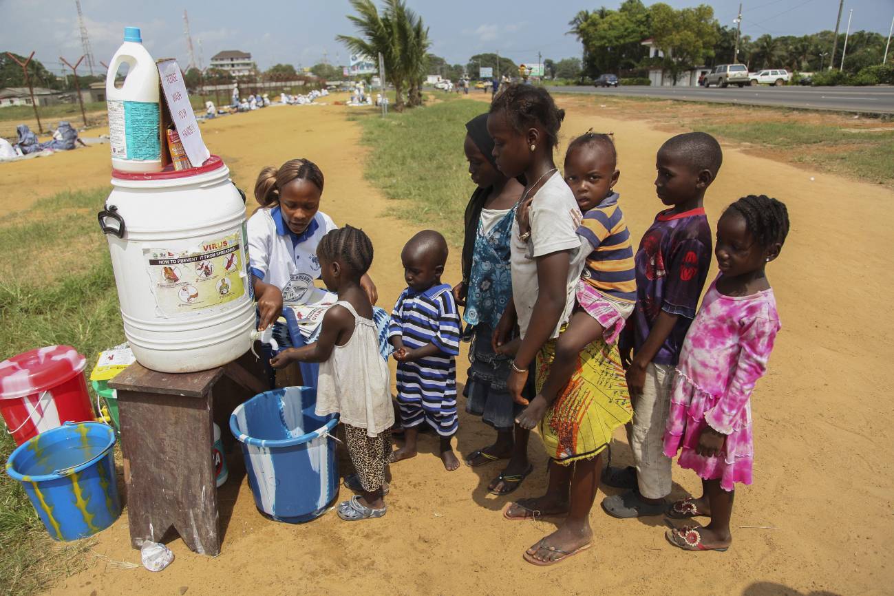 Niños se lavan las manos en una aldea de Liberia. / Efe
