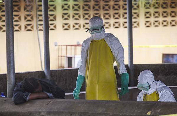  Trabajadores de salud liberianos se preparan para recoger el cuerpo de una víctima del ébola del área de espera de un hospital en Monrovia. / Efe