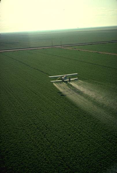Avión rociando un campo de cultivo con plaguicida. Foto: PD-USGOV-USDA.