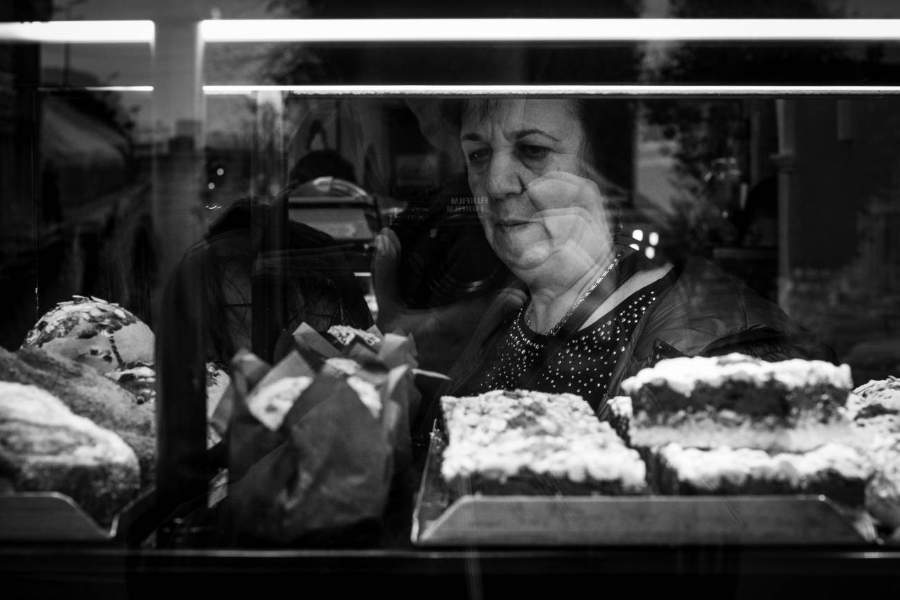 Mujer mayor mirando una vitrina con pasteles. Imagen: Pxhere.com