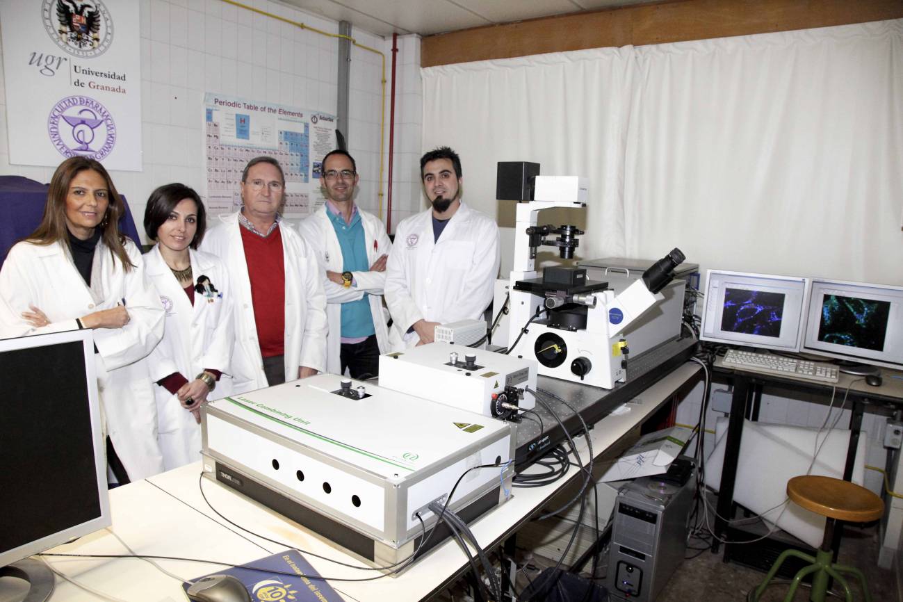 Los investigadores de la UGR autores de la patente posan junto al microscopio de fluorescencia, en la Facultad de Farmacia.