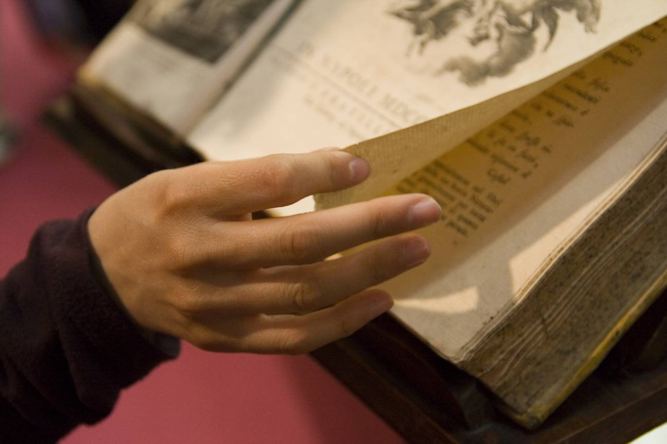 Unas manos pasando las hojas de un libro antiguo