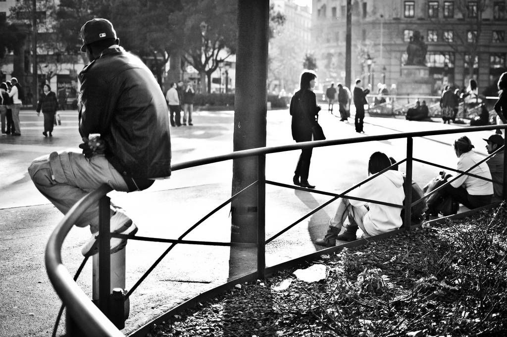 Joven sentado en una plaza de Barcelona. / David Flores