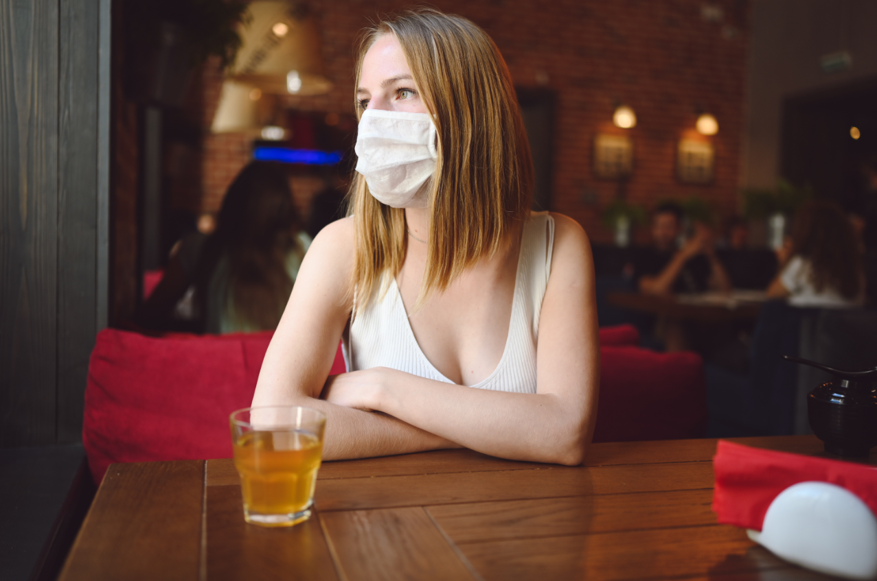 mujer con mascarilla dentro de un bar 