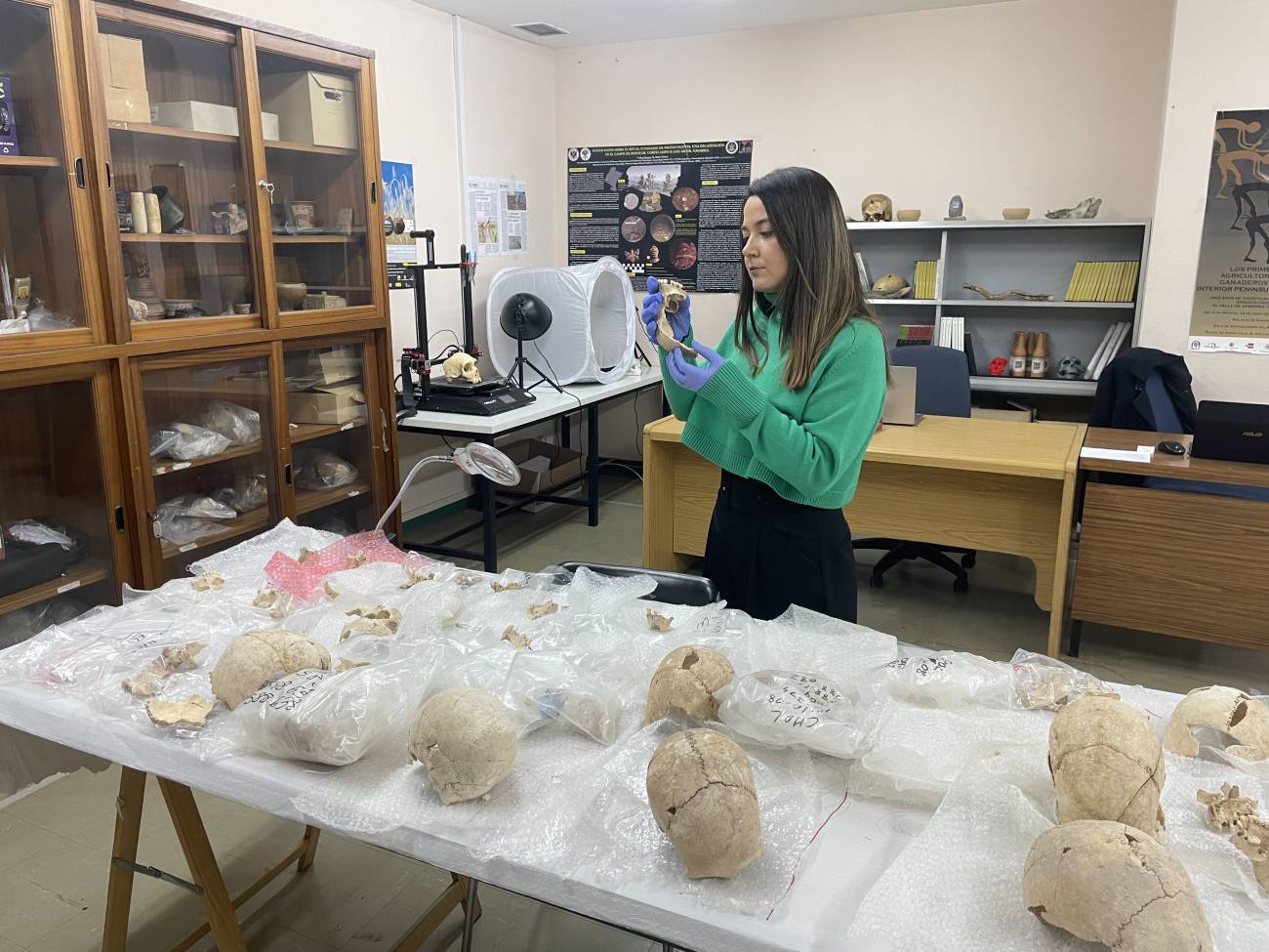 antropóloga examina un fragmento de un cráneo