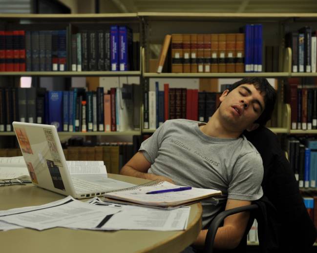 hombre durmiendo en una biblioteca