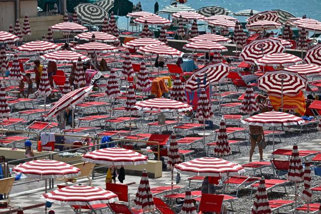 Bañistas buscan refugio del sol en una playa italiana en julio de 2023