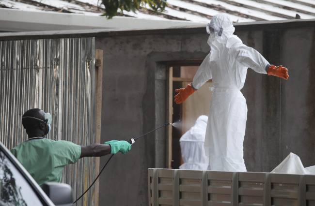 Personal médico es desinfectado después de tratar contagiados de ébola. / Efe