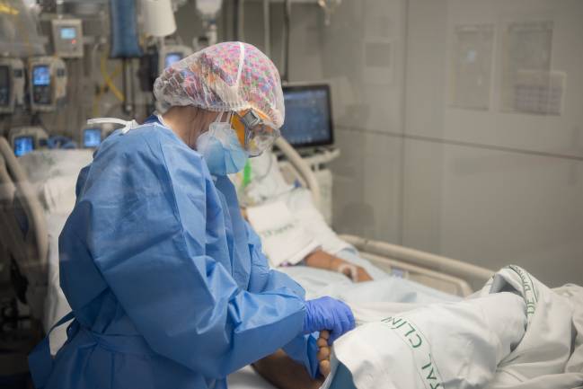 Una sanitaria cuida de un paciente con covid-19 en el Hospital Clínico de Barcelona