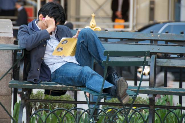 Persona leyendo en el banco de un parque