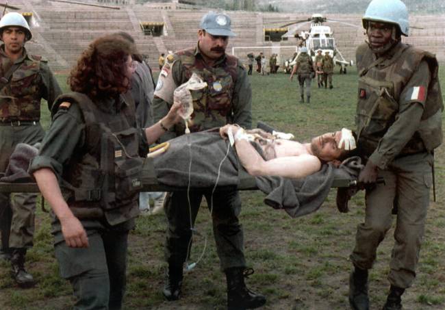 Soldados de la ONU trasladan a un herido en el estadio Kosovo en Sarajevo en abril de 1994. / Efe