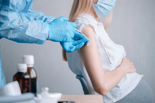 Mujer embarazada a la que le están administrando una vacuna