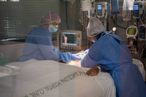 Personal sanitario atiende a una persona ingresada por covid-19 en el Hospital Clínic