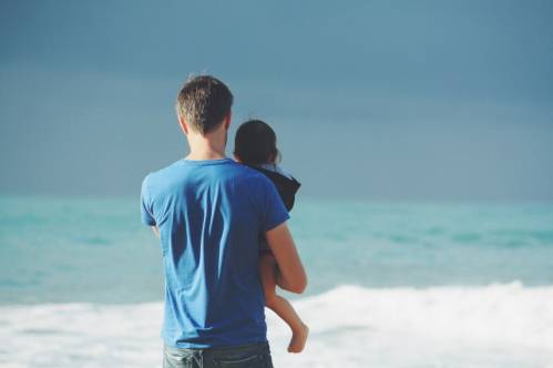 Un padre con un niño frente al mar