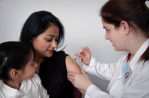 Enfermera vacuna a una mujer